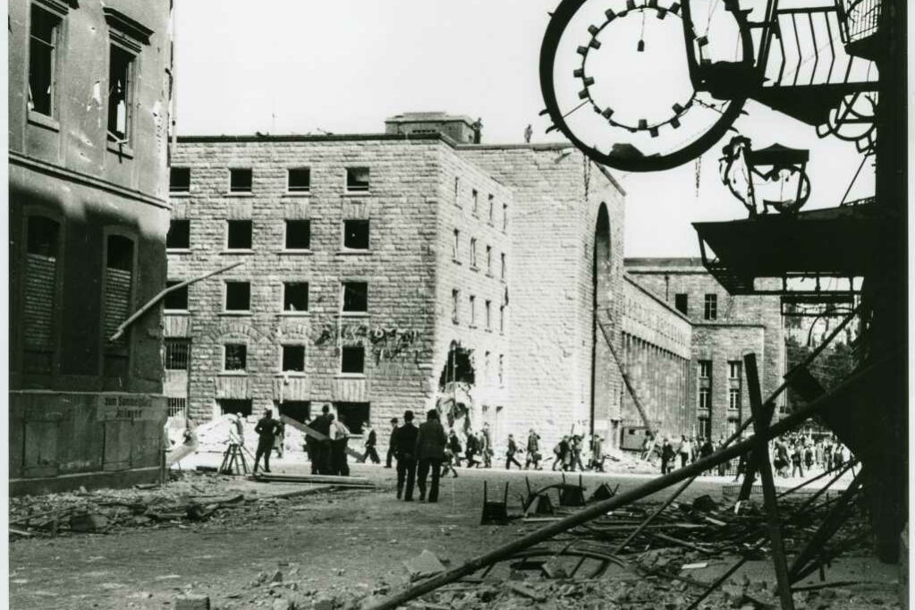 Schwar-weiß Aufnahme des Hauptbahnhofs Stuttgart mit eingestürzten Mauern und Zerstörungen durch Fliegerbomben